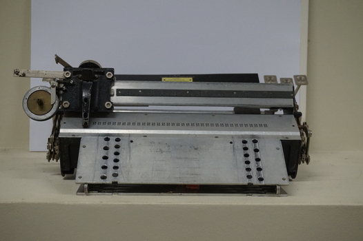 Metal rectangular plates joined with metal keys and connecting puncher that moves across the page