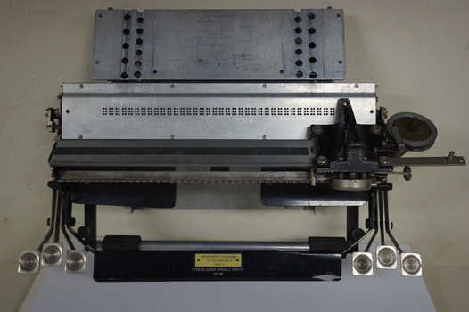 Metal rectangular plates joined with metal keys and connecting puncher that moves across the page
