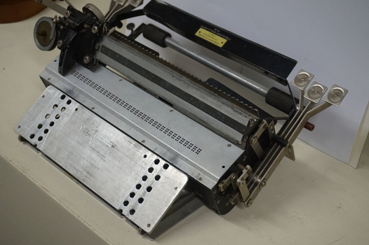 Metal rectangular plates joined with metal keys and connecting puncher that moves across the page