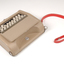 Tan case with flip top lid exposing keyboard, and red handle strap