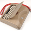 Tan case with flip top lid exposing keyboard, and red handle strap