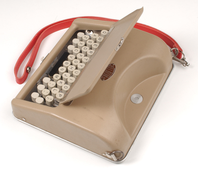 Tan case with flip top lid exposing keyboard, and red handle strap
