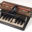 Piano like keyboard on black iron base with metal rollers