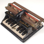 Piano like keyboard on black iron base with metal rollers