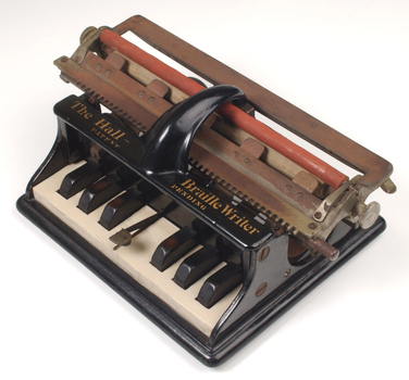 Piano like keyboard on black iron base with metal rollers