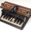 Piano like keyboard on black iron base with metal rollers