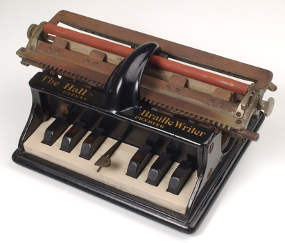 Piano like keyboard on black iron base with metal rollers
