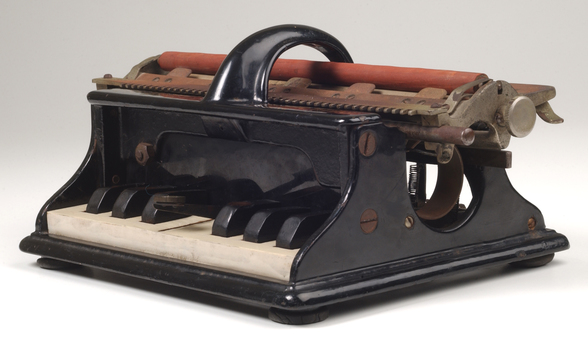 Piano like keyboard on black iron base with metal rollers