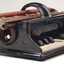 Piano like keyboard on black iron base with metal rollers