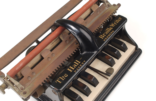 Piano like keyboard on black iron base with metal rollers