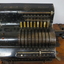 Black register shaped object on wooden board with metal levels and handles.