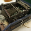 Black and silver brailler in disintegrating green felt box