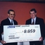 Two men hold an oversized cheque for $8859