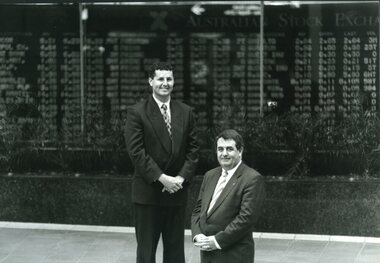 Two men stand outside stock exchange