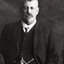 Bearded man with hand in waistcoat pocket near his fob watch