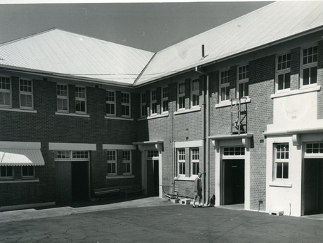 Man walking into brick 2 storey building