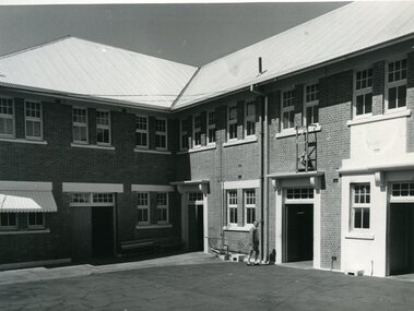 Man walking into brick 2 storey building