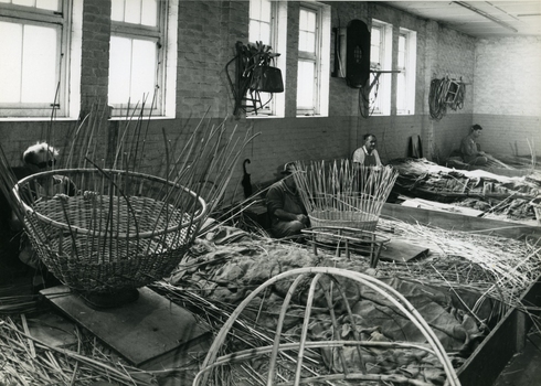 Other side of workshop, with four men making wicker baskets