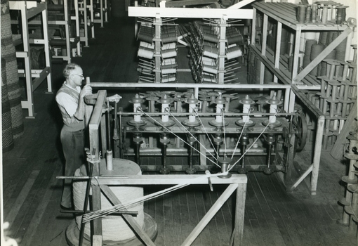 Man observing bobbin winder and bobbin bank