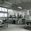 Men stand at workstations working on various types of brushes