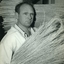 Man holds millet stalks in a bundle