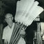 Older man lifting completed millet brooms