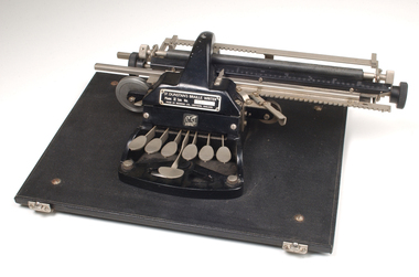 Metal Braille typewriter attached to rectangle base board