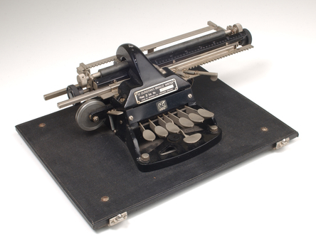 Metal Braille typewriter attached to rectangle base board