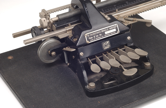Metal Braille typewriter attached to rectangle base board