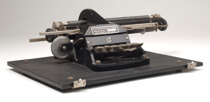 Metal Braille typewriter attached to rectangle base board