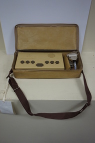 Tan rectangular box in vinyl bag