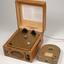 Wooden box with metal grill in front and two clasps.  A golden cartridge sits beside the player.