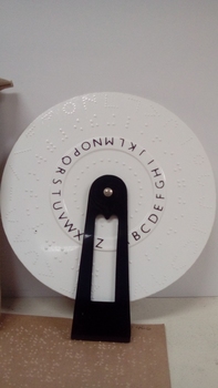 Round wheel with Braille held by a black plastic handle
