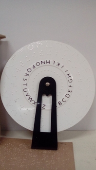 Round wheel with Braille held by a black plastic handle