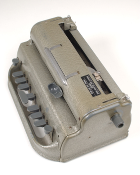Metal Braille writer with nine grey keys, carriage return key and paper rollers on either side