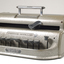 Metal Braille writer with nine grey keys, carriage return key and paper rollers on either side
