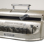 Metal Braille writer with nine grey keys, carriage return key and paper rollers on either side