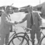 Two men shake hands whilst holding a Mitchell bicycle