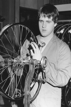 Mitchell cycle worker working on a wheel, with his hand on a spoke