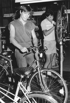 Two men working on bicycles in factory