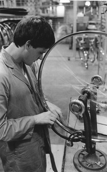 Worker at Mitchell cycles, putting together a wheel rim