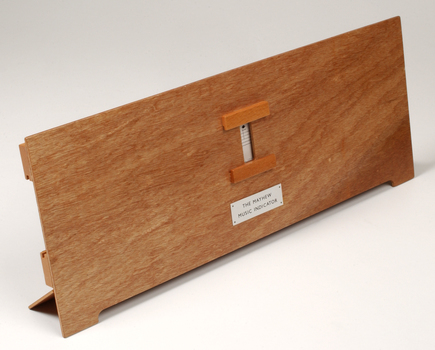 Front view of wooden board with gap in the middle showing music staff