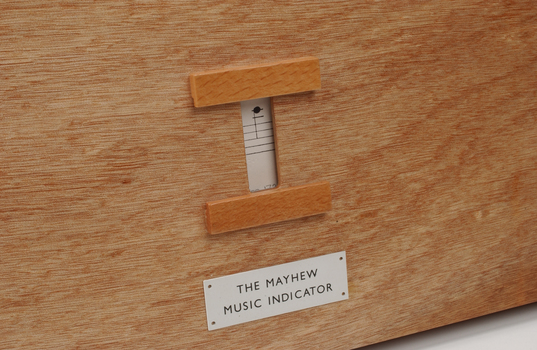 Front view of wooden board with gap in the middle showing music staff