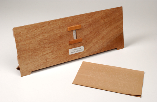 Front view of wooden board with gap in the middle showing music staff