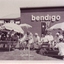 Residents sit in the shade outside building