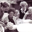 Female resident holds a baby surrounded by two staff and another resident