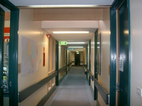 View down hallway from front left side of building down to orthoptist and gold edged portraits of Wicking and Daubney
