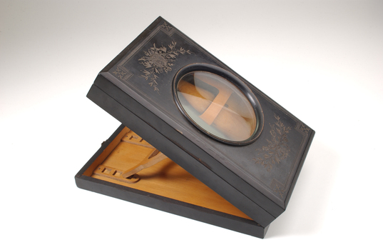 1 wooden box with fold out top and inset glass magnifier.
