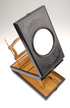 1 wooden box with fold out top and inset glass magnifier.