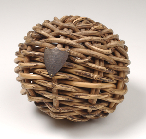 Braided wicker in ball shape with miniature metal shield attached